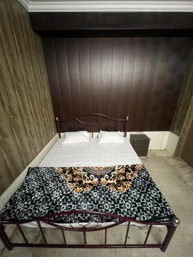 a bed with a black and white blanket on it at Triveni Sangam Homestay in Prayagraj