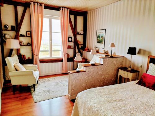 une chambre avec un lit, une chaise et une fenêtre dans l'établissement Le Clos Lauradière, à Cormeilles