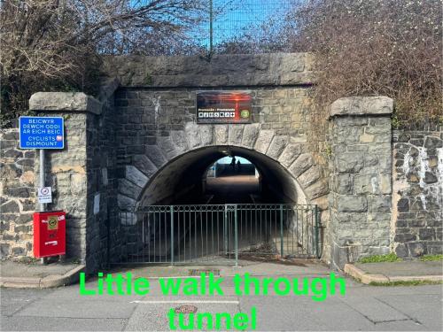 a tunnel with a sign in the middle of it at Lovely New 2 Bedroom Condo with Stunning Seaviews in Penmaen-mawr