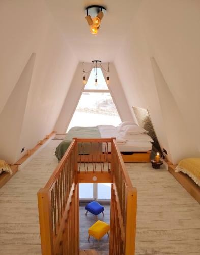 a attic bedroom with a bed and a window at Alloria in Şirnea