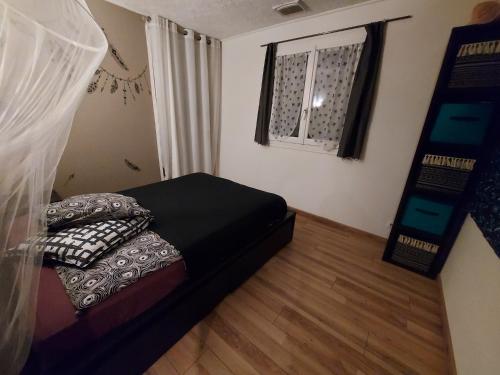 une petite chambre avec un lit et une fenêtre dans l'établissement Charmante maison, à Paulhan