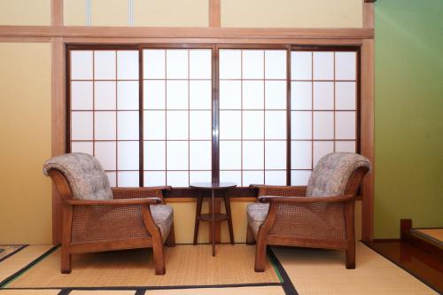 due sedie e un tavolo davanti a una finestra di Golden Fox Inn, Old house in the old city, Walking distance to Matsumoto Castle and tourist attractions a Matsumoto