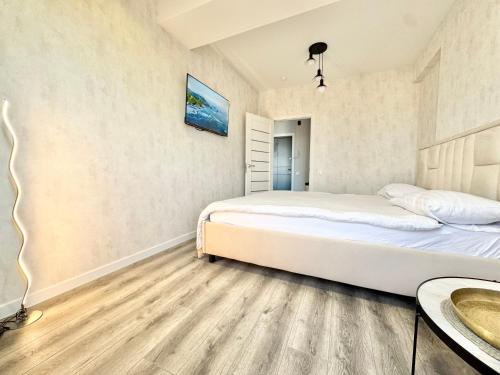 a bedroom with two beds and a table at Уютные апартаменты в новострое на Ботанике in Chişinău
