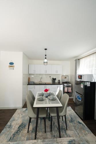 a kitchen with a table and chairs in a room at Arabella Luxe Near Waterfront Mall - Karen in Nairobi