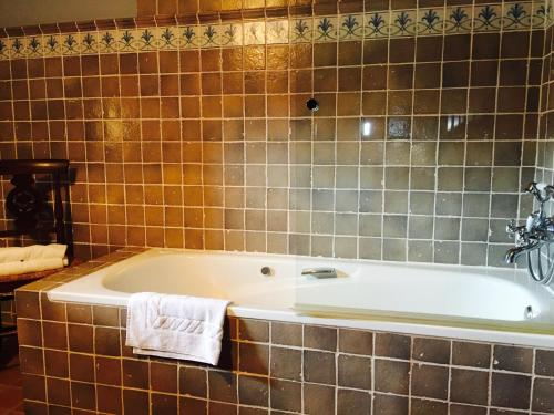 a bath tub in a bathroom with brown tiles at Batzarki in Avellaneda