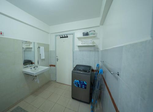 a bathroom with a trash can and a sink at Arabella Luxe Near Waterfront Mall - Karen in Nairobi