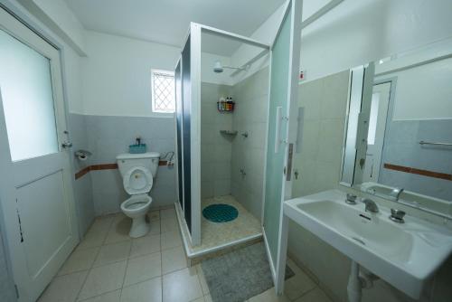 a bathroom with a toilet and a sink and a shower at Arabella Luxe Near Waterfront Mall - Karen in Nairobi