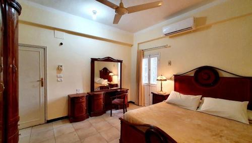 a bedroom with a bed and a dresser and a mirror at Cream Hostel in Luxor