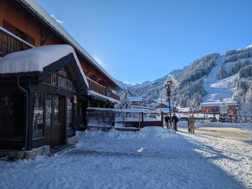 a snow covered street in front of a building at Hôtel Les Grangettes in Méribel