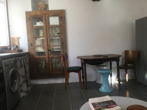 a room with a table and a wooden cabinet at Maison à Porticciolo, idéale pour un couple in Cagnano