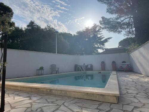 - une piscine à côté d'un mur blanc et d'un mur blanc dans l'établissement Villa arborée - piscine, à Saint-Jean-de-Védas