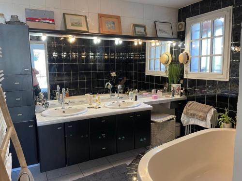 Un baño con dos lavabos y una bañera. en Villa arborée - piscine, en Saint-Jean-de-Védas