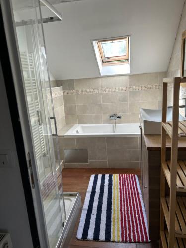 une salle de bain avec une baignoire et un lavabo dans l'établissement Longère à la campagne, à Montigny-Lengrain