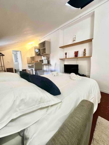 - une chambre avec 2 lits blancs et une cheminée dans l'établissement Charmant studio Vieux Nice, à Nice