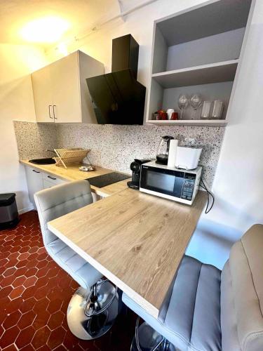 une cuisine avec une table et un four micro-ondes. dans l'établissement Charmant studio Vieux Nice, à Nice