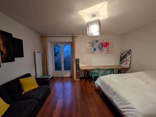 a bedroom with a bed and a desk and a couch at Joli appartement en centre-ville in Poitiers