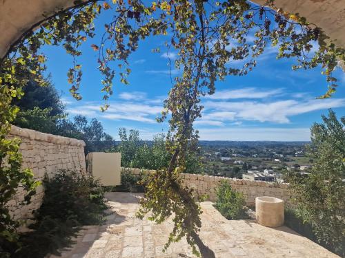 a view of the city through an arch in a wall at CRIO - Experiences at home in Cisternino