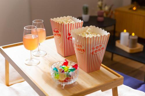 a table with two glasses of popcorn and a bowl of candy at Movie Prestige - Elegant - Moderne - Netflix avec VidéoProjecteur - Stationnement facile in Laigneville