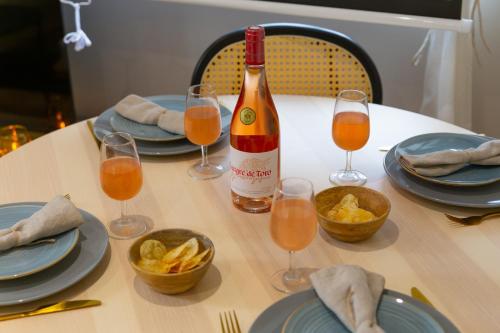 a table with a bottle of wine and glasses of food at Movie Prestige - Elegant - Moderne - Netflix avec VidéoProjecteur - Stationnement facile in Laigneville