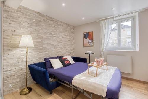 a bedroom with a blue bed and a brick wall at Movie Prestige - Elegant - Moderne - Netflix avec VidéoProjecteur - Stationnement facile in Laigneville