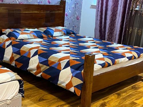 a bed with a colorful comforter on top of it at Perfect Stay Near Glasgow Town in Glasgow