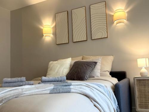 une chambre avec un lit avec trois tableaux au mur dans l'établissement Grand Studio au coeur de Deauville I La Place de Morny et La Gare sont à 5 min à pied, à Deauville