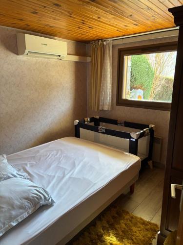 Ce lit se trouve dans un dortoir doté d'une fenêtre et d'une sidx. dans l'établissement Appartement typique 3 pièces - La Bresse, à La Bresse