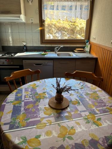 une cuisine avec une table ornée de motifs floraux dans l'établissement Appartement typique 3 pièces - La Bresse, à La Bresse