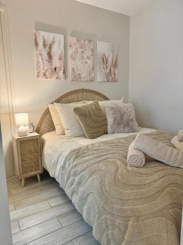 - un lit dans une chambre avec 3 photos sur le mur dans l'établissement Grand Studio au coeur de Deauville I La Place de Morny et La Gare sont à 5 min à pied, à Deauville