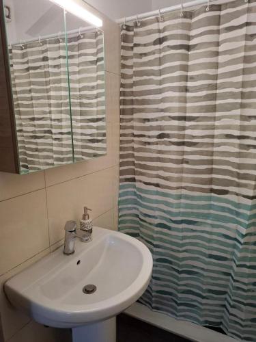 a bathroom with a sink and a shower curtain at Romantic Sparta Hideaway in Sparta