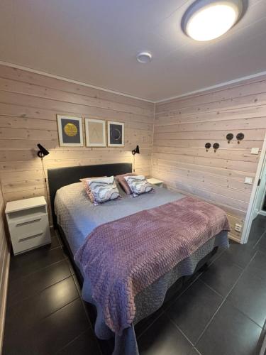 a bedroom with a bed with a purple blanket at Villa Havu holiday home in Pyhä/Lapland in Pyhätunturi