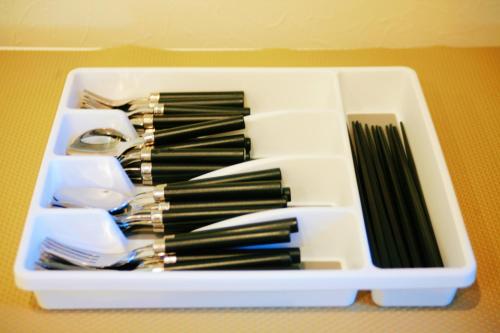 a plastic container filled with utensils and chopsticks at 千鳥3号天然温泉付別荘 in Shirahama