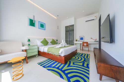 Un dormitorio con una cama, un televisor y un sofá. en HappyHouse, en Pattaya South