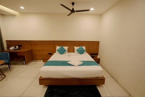 a bedroom with a bed with a ceiling fan at Stayon Hotels in Palakkad
