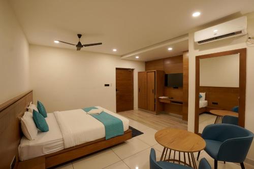 a bedroom with a bed and a table and chairs at Stayon Hotels in Palakkad