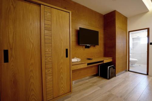 a room with a television and a wooden wall at Stayon Hotels in Palakkad