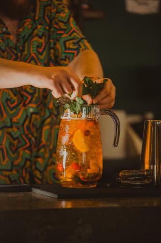 a person is putting ingredients in a jar of food at Hôtel Les Grangettes in Méribel