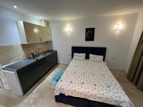 une petite chambre avec un lit et un lavabo dans l'établissement ORBI Residence LUXURY, à Batoumi