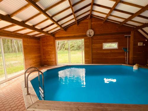 - une grande piscine dans une maison en bois dans l'établissement Magnifique propriété avec piscine chauffée, à Varennes-en-Gâtinais