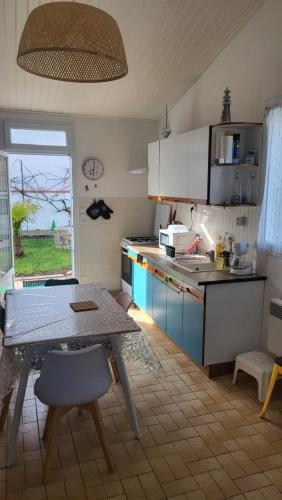 une cuisine avec une table et un comptoir dans l'établissement JujuJajaCo, à Grand-Village-Plage