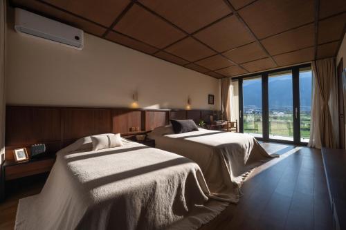 大理Free To Be Wild Designer Hotel的有两张床和一扇大窗户的酒店房间