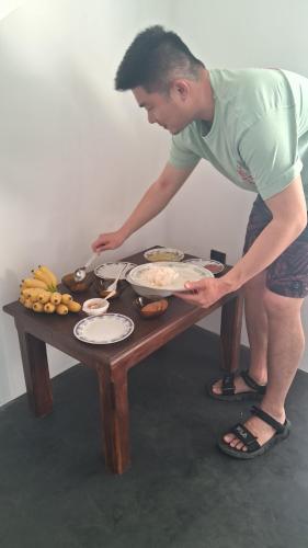 a man standing over a table with plates of food at RKO Villa27 - Unawatuna in Habaraduwa