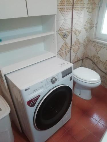 a washing machine in a bathroom with a toilet at Vista mare in Calasetta