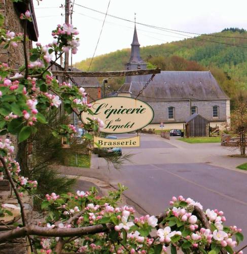 a sign for a tavern in a village with a church at Appart Hotel Au Pied de Vigne in Vresse-sur-Semois