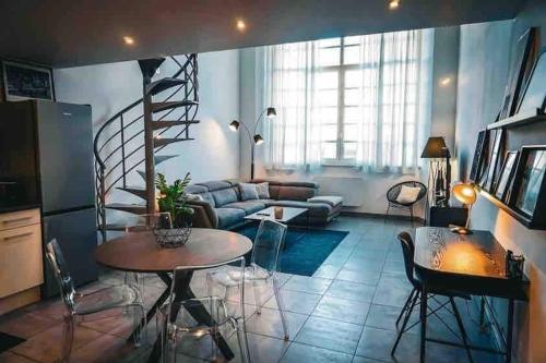 un salon avec un escalier en colimaçon et une table dans l'établissement I Loft You, à Belfort