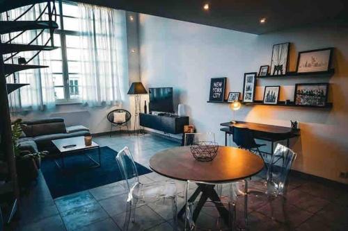 Una sala de estar con un sofá, una mesa y sillas. en I Loft You, en Belfort