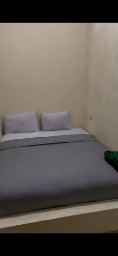 a white bed with two pillows on top of it at Hotel De kock BnB in Bukittinggi