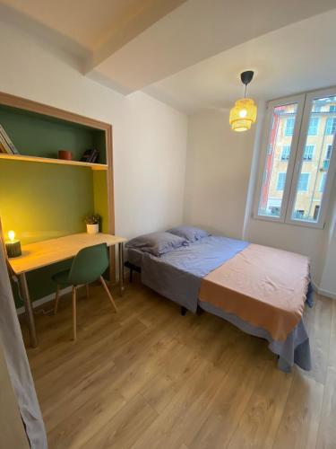 une chambre avec un lit, un bureau et une table dans l'établissement Cosy Appartement Vieux Nice, à Nice