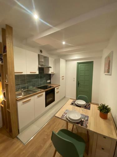 une cuisine avec une table et une porte verte dans l'établissement Cosy Appartement Vieux Nice, à Nice