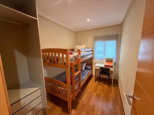 a small room with two bunk beds and a desk at Cozy apartment for 7 people - Port Aventura in Vila-seca